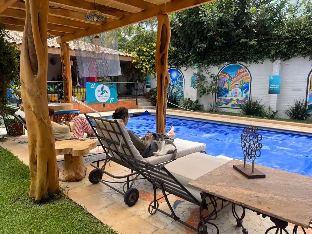 Pet-Friendly Assisted Living in Mexico 2 Resident of Casa Zoe community laying by the pool next to her cat