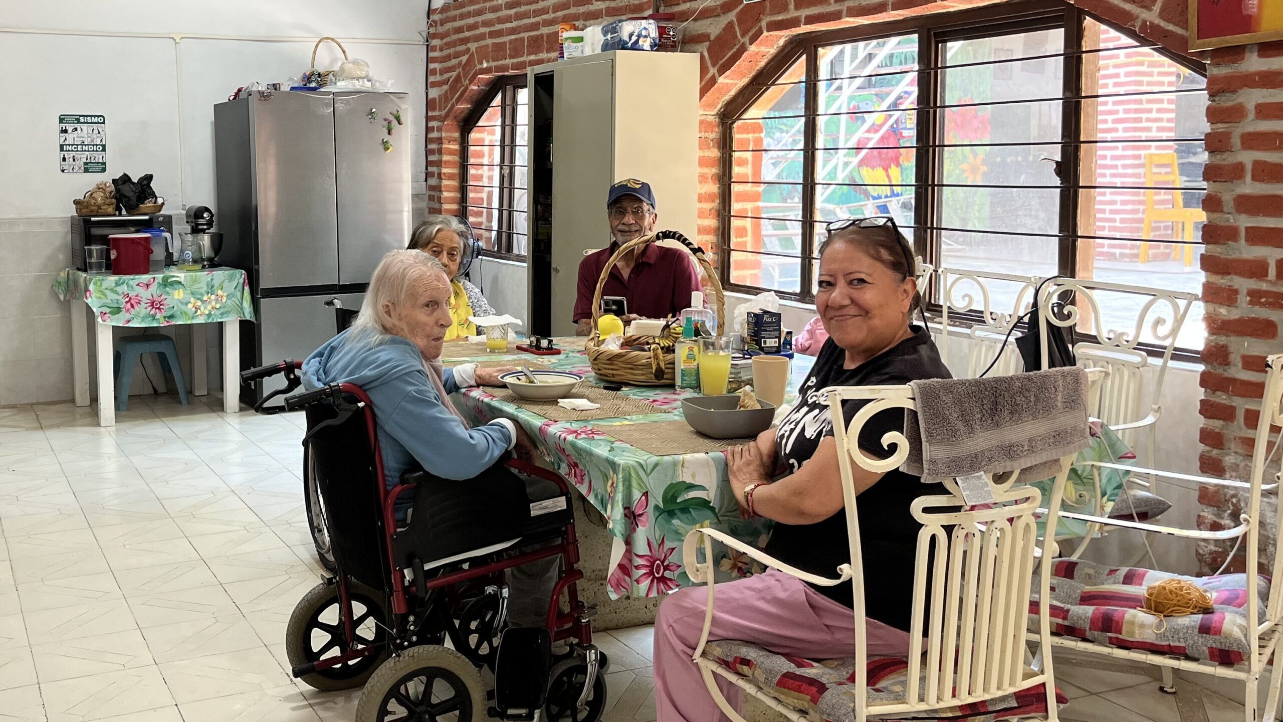 Residents and a caregiver having lunch together in the dining area of Shila's House, a nursing home in Ixtlahuacán de los Membrillos, Mexico