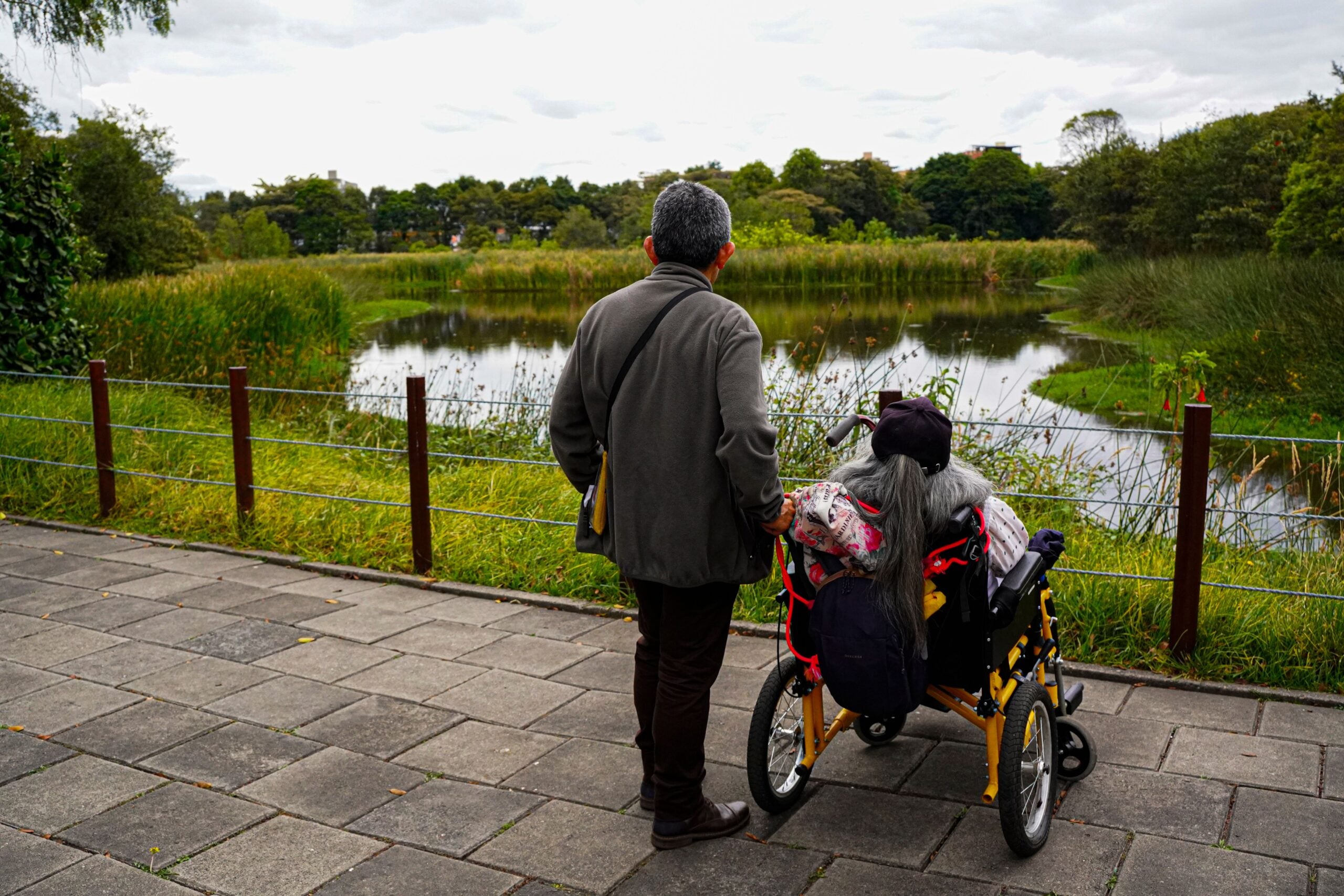 Senior couple staring into a pond scaled
